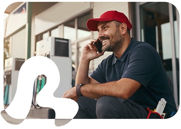 Man smiling on phone in front of convenience store
