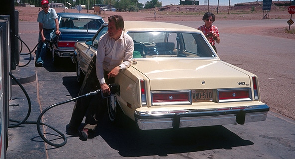 Man filling up a classic car at a gas pump